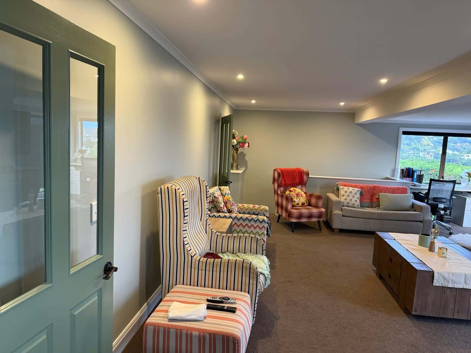 A freshly painted living room with a sage-green panelled door
